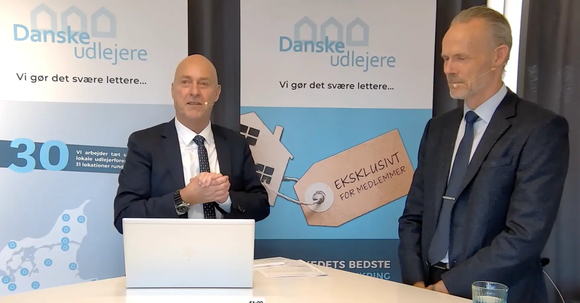 To oplægsholdere livestreamer fra Danske Udlejeres lokation med bannere