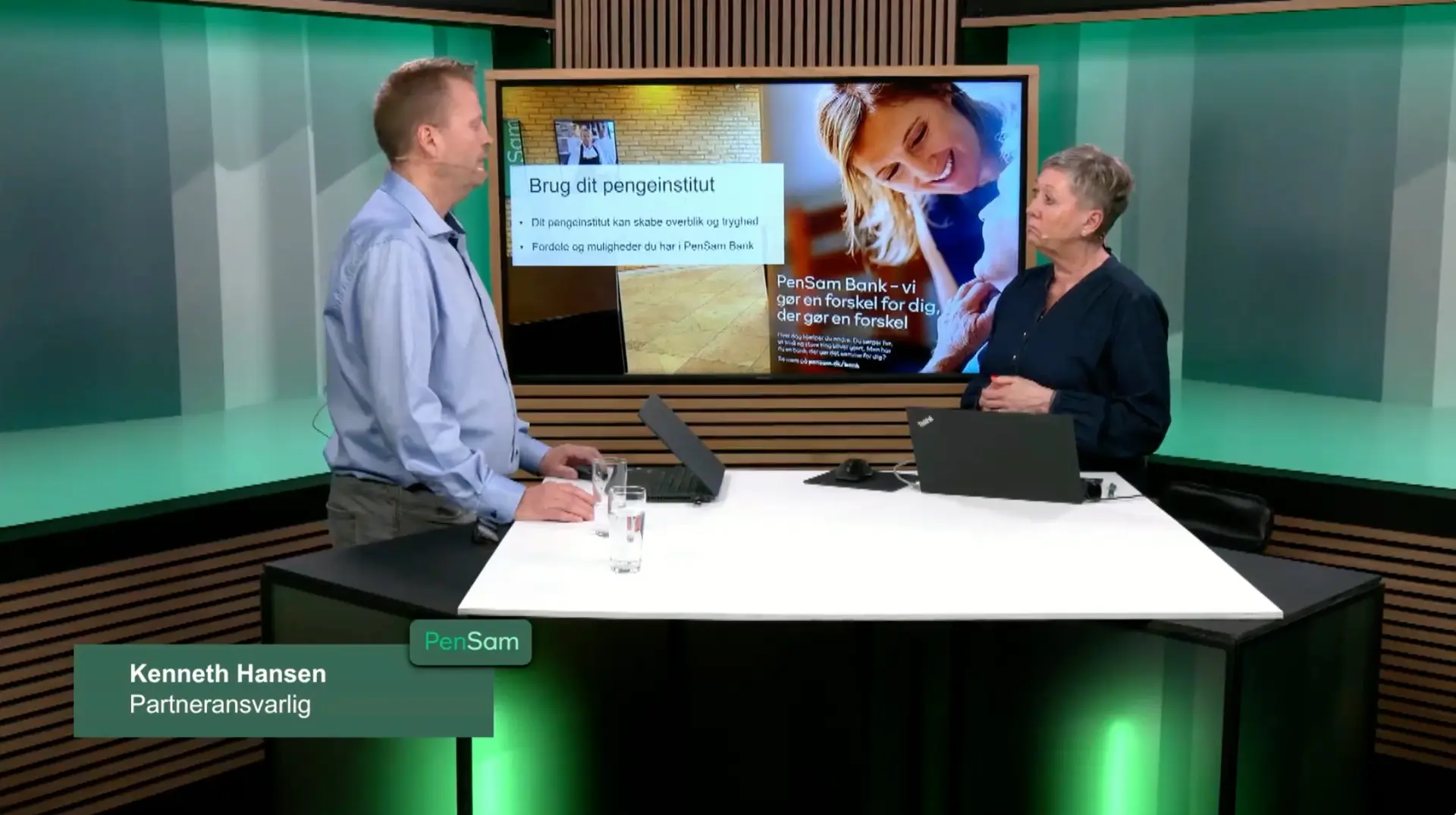To værter i TV-studie med storskærm under et webinar for PenSam